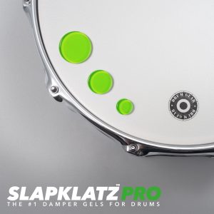 3 alien green SlapKlatz drum dampeners in different sizes, all on a white drum head